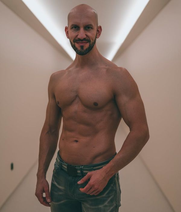 Athletic man performing a strength exercise in a bright, modern space.